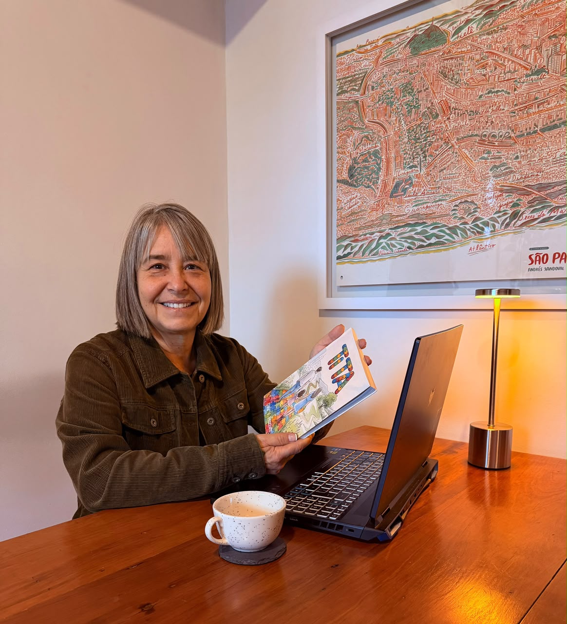 Cátia V. Frazzatto, autora de Tita, sorrindo e segurando seu livro.